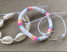 two bracelets with seashells on them sitting on the floor