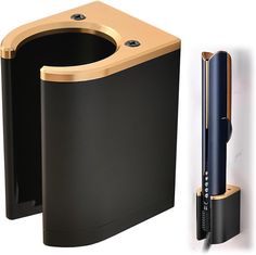 a black and gold toilet next to a wall mounted toothbrush dispenser