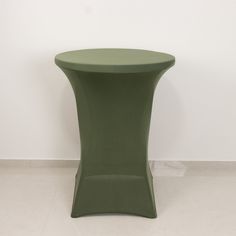 a green table sitting on top of a white floor