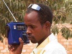 a man holding an old fashioned radio in his hand