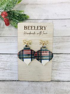 Adorable and classic Dublin plaid ornament earrings have arrived!  These Christmas ornament dangles are handcrafted and have the sweetest gold bow stud.  Not a fan of gold?  Silver bows are available too!   These adorable ornaments will be a great gift or stocking stuffer! ---------- DETAILS  ---------- * Handcrafted ornaments are cut from genuine leather backed Cork * Lightweight as always! * Your choice of gold or silver colored stud bow. * Firm yet pliable  * Ornament length measures 1.5" ( bow adds a slight more to the total length, see listing picture for measurements). * Beautiful Dublin Plaid printed Cork is backed in a rich, dark brown genuine leather. **PLEASE NOTE** DUE TO PATTERN VARIATIONS IN THE LEATHER BACKED CORK, PAIRS MAY NOT MATCH THE EXACT PAIR LISTED**  U.S. shipping is Ornament Earrings, Handcrafted Ornaments, Boho Style Earrings, Jewelry Care Instructions, Macrame Earrings, Earrings Christmas, Silver Bow, Christmas Earrings, Small Earrings