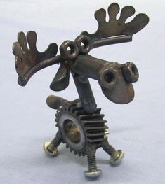 a metal sculpture of a moose holding a gear wheel with one hand and wearing antlers on its head