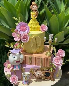 the cake is decorated with princess figurines and flowers