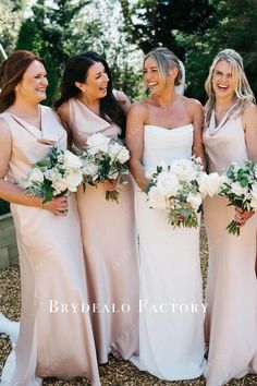 the bridesmaids are all dressed in pink dresses and bouquets smiling for the camera