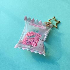 a pink donut with sprinkles in a bag on a blue surface