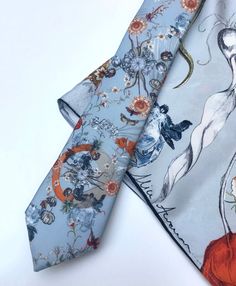 An unusual Silk Twill Tie and coordinating pocket square or little scarf with x-ray crab and tulip design. The 'Evolution' Tie and pocket square with a pale blue ground, features vintage style illustrations created by hand and digitally printed onto high quality silk. The unique design was inspired by the infinite complexities of nature and the fascinating theory of evolution with details including scientific illustration style tulips and x-ray image of a crab, moths and pineapples. The colour p Blue Pocket Square For Wedding, Blue Groom Suit Accessories With Pocket Square, Elegant Summer Handkerchiefs As Gifts, Rectangular Pocket Square As A Gift, Blue Ties With Pocket Square For Wedding, Blue Ties And Pocket Square For Groom, Blue Tie With Pocket Square For Groom, Elegant Blue Pocket Square As Gift, Elegant Blue Pocket Square For Gift