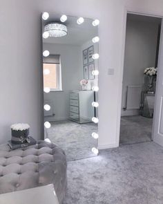 a large mirror with lights on it in a room