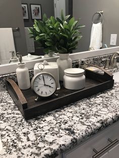 a bathroom counter with a clock, soap dispenser and other items