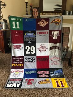 a woman is holding up a quilt made to look like it has many different teams on it