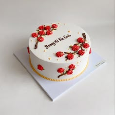 a white cake decorated with red roses and the words sorry to you on it's side