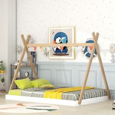 a child's bedroom with a bed and artwork on the wall