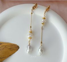 These earrings feature genuine freshwater baroque pearls delicately connected with small, varied shapes of Keshi pearls, creating an enchanting asymmetrical design and graceful lines.  P E A R L ∙ E A R R I N G S ✨Total Length : about 8.5 cm ✨Color: natural untreated, metallic white with tint of blue overtone ✨Material: Ear studs are gold plated S925 sterling silver, suitable for sensitive skin.  It is nickel free, hypoallergenic, tarnish resistant O T H E R ∙ I N F O R M A T I O N ✨ Our pieces are made with care and attention to details. ✨Freshwater pearls are entirely natural, which means that each one has its own distinct size and shape. I'll take care to ensure that the pearls harmonize beautifully with each other. ✨ The orders typically take 1-3 days to process.  ✨ Your satisfaction i Handmade Delicate Baroque Pearl Earrings, Delicate Baroque Pearl Earrings With Pearl Charm, Delicate Handmade Baroque Pearl Earrings, Delicate Baroque Pearl White Earrings, Handmade Pearl Pendant Earrings For Jewelry Making, Pearl Pendant Earrings For Jewelry Making, Dainty Baroque Pearl Dangle Jewelry, Dangle Earrings With Baroque Pearl Chain, Minimalist Baroque Pearl Earrings With Pearl Chain