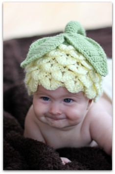 a baby wearing a crocheted hat on top of a blanket