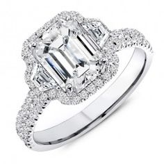 an emerald cut diamond engagement ring with double halos on the shoulders and side stones