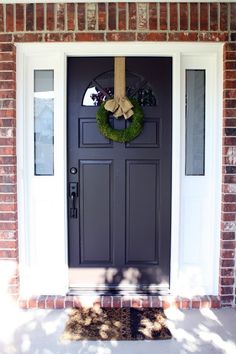 a black front door with a wreath on it