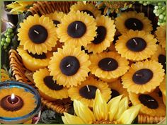 sunflowers with candles in the middle of them are arranged on a wicker basket