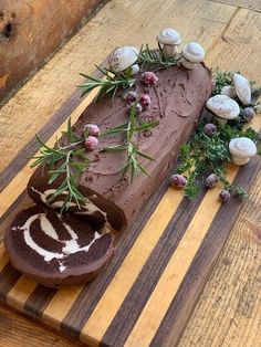 a piece of chocolate cake sitting on top of a wooden cutting board next to mushrooms