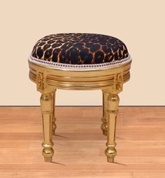 a leopard print ottoman sitting on top of a hard wood floor next to a wall