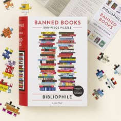 the book is surrounded by puzzles and books on top of each other, including one that reads banned books