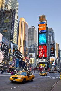 a busy city street filled with lots of tall buildings and billboards in the distance