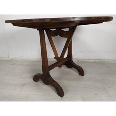 an old wooden table sitting on top of a white tile floor next to a wall