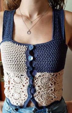 a close up of a person wearing a top with crocheted buttons on it