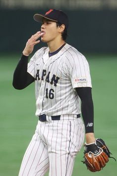 a baseball player with his hand in his mouth