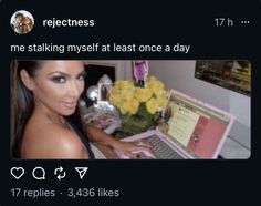 a woman sitting in front of a laptop computer on top of a desk with flowers