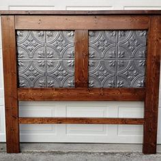 a wooden headboard with metal panels on it's sides, against a white brick wall