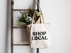 "Shop Local"Designed with love and printed by hand, this heavy canvas tote bag is the perfect eco-conscious companion for your local market trips! Eco-friendly Cotton Canvas Market Bag, Eco-friendly Canvas Bag For Market, Eco-friendly Canvas Bag, Cotton Tote Canvas Bag For Market, Cotton Canvas Tote Bag For Market, Eco-friendly Canvas Shopping Bag, Organic Style Tote Bag For Shopping, Organic Tote Bag For Shopping, Eco-friendly Tote Canvas Bag For Shopping