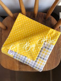 a yellow and white polka dot cloth on top of a wooden chair