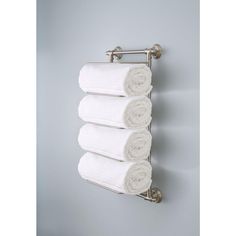 four white towels are hanging on the wall next to each other in a towel rack