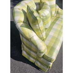 a green and white checkered couch sitting on the ground