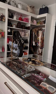 a closet filled with lots of purses and handbags next to a counter top