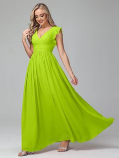 a woman in a bright green dress poses for the camera with her hands on her hips