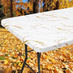 an ironing board sitting on top of a table covered in leaves and autumn foliage