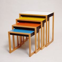 three wooden tables with different colored tops