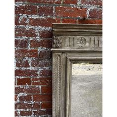 an old mirror is leaning against a brick wall