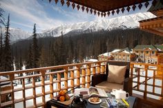 a table with food on top of it in front of a balcony overlooking the mountains