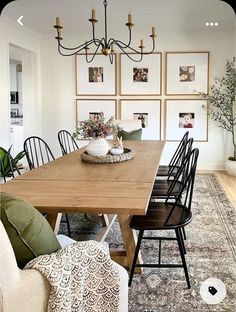 a dining room table with chairs and pictures on the wall behind it, along with an area rug