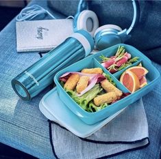 there is a blue tray with food and headphones on it