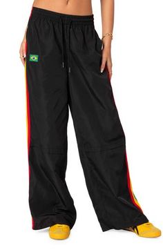 Unleash your sporty vibe in these modern track pants designed with colorful stripes racing down the sides. 100% polyester Machine wash, dry flat Imported Black Pants With Contrast Stripes For Streetwear, Sporty Black Sweatpants With Contrast Stripes, Gym Pants With Side Stripes In Black, Black Nylon Sporty Sweatpants, Black Sporty Nylon Sweatpants, Sporty Multicolor Nylon Bottoms, Black Gym Pants With Side Stripes, Black Athleisure Joggers With Side Stripes, Sporty Black Pants With Side Stripes