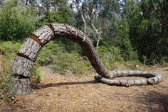 a wooden arch made out of logs in the woods