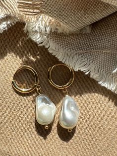 Beautiful earrings with freshwater pearls. Because the pearl is a natural freshwater pearl, there are no two pearls with the exact same shape. The gold hoop earrings add to her elegant look and the earrings go perfectly with an elegant outfit, but can also be worn every day. What makes our jewelry special? 🌊 The high-quality, gold-plated stainless steel makes the jewelry waterproof ✨ No discoloration, no green edges 🌿 Allergy friendly 🫀 Each piece of jewelry is selected with love and lovingly Wedding Jewelry Ideas For Bride Pearls, 14k Gold Filled Pearl Drop Earrings For Anniversary, Classic Pearl Huggie Jewelry, Pearl Charm Huggie Jewelry For Anniversary, Gold Pearl Huggie Jewelry, Baroque Pearl Charm Hoop Earrings, Huggie Pearl Charm Jewelry For Anniversary, Yellow Gold Hoop Earrings With Pearl Drop For Gift, Anniversary Huggie Jewelry With Pearl Charm