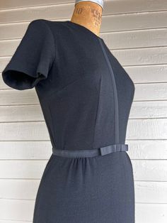 "This is a 'little black dress' in wool that you can wear for any occasion if you accessorize properly! The simple grosgrain ribbon with a bow at the waist adds just the right amount of detail to this classic piece. I love the short sleeves in wool, which I think make it more wearable. It is in very good vintage condition with the only flaw being a handful of tiny moth holes due to improper storage (see photos). I don't think that it affects the wearability at all, especially if you wear a black Short Sleeved Dress, Sleeved Dress, Black Slip Ons, Black Wool, Dress Clothes For Women, Grosgrain Ribbon, Skirt Length, Little Black Dress, Short Sleeve Dresses