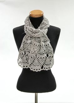 a white crocheted scarf on a mannequin