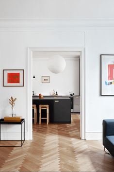 a living room filled with furniture and pictures on the wall next to a dining table