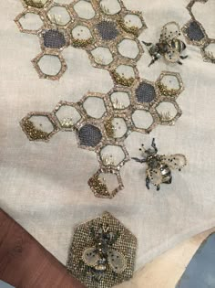 several pieces of beaded fabric with bees on them