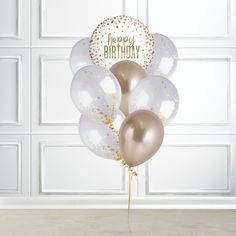 three balloons with gold and white confetti on them are in front of a wall that says happy birthday