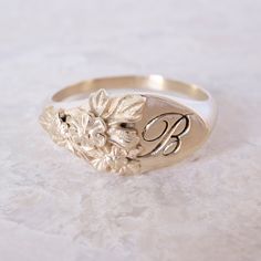 This vintage-inspired floral ring is a row of dainty flowers wrapped around your fingers. Handmade and polished, it is available in solid 8K and 14K gold. This item is engravable with text or monogram of your choice at no extra cost. The initals are engraved onto the ring and embedded in the 3D model for a flawless embossed finish. It is also possible to add a diamond or birthstone or diamond to this ring at an additional fee. Please inquire for details. A few notes about our gold: - Though we d Luxury Brilliant Cut Engraved Ring, Luxury Gold Signet Ring With Diamond Accents, Luxury Wedding Signet Ring With Cubic Zirconia, Luxury Wedding Signet Ring With Single Diamond, Luxury Gold Signet Ring With Halo Setting, Luxury Ceremonial Hallmarked Signet Ring, Luxury Vintage Signet Ring With Diamond Accents, Luxury Vintage Engraved Ring With Hallmarks, Luxury Art Deco Signet Ring As A Gift